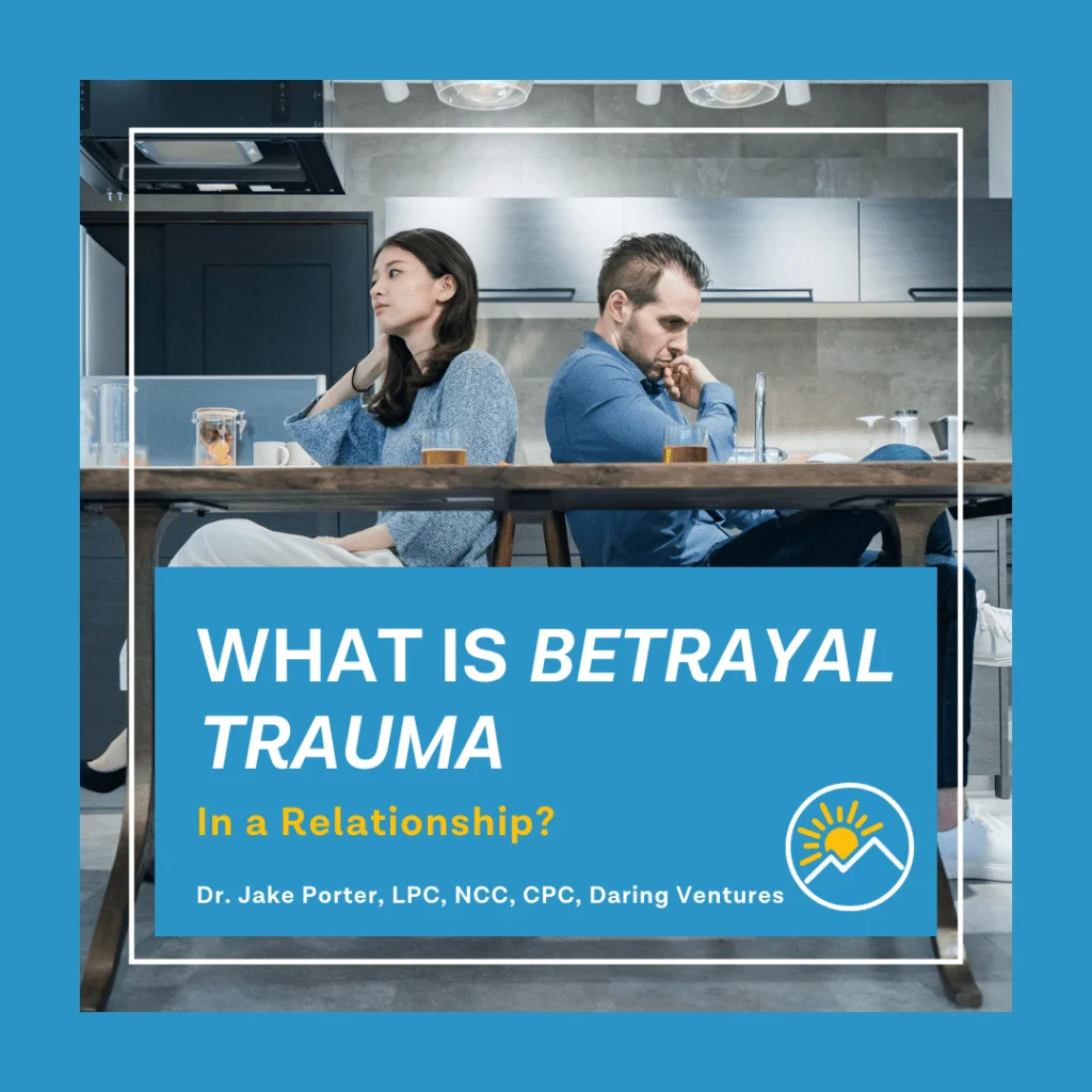 A couple sitting back-to-back at a kitchen table, not speaking, under the title "What is Betrayal Trauma in a Relationship?" by Dr. Jake Porter, LPC, NCC, CPC, Daring Ventures